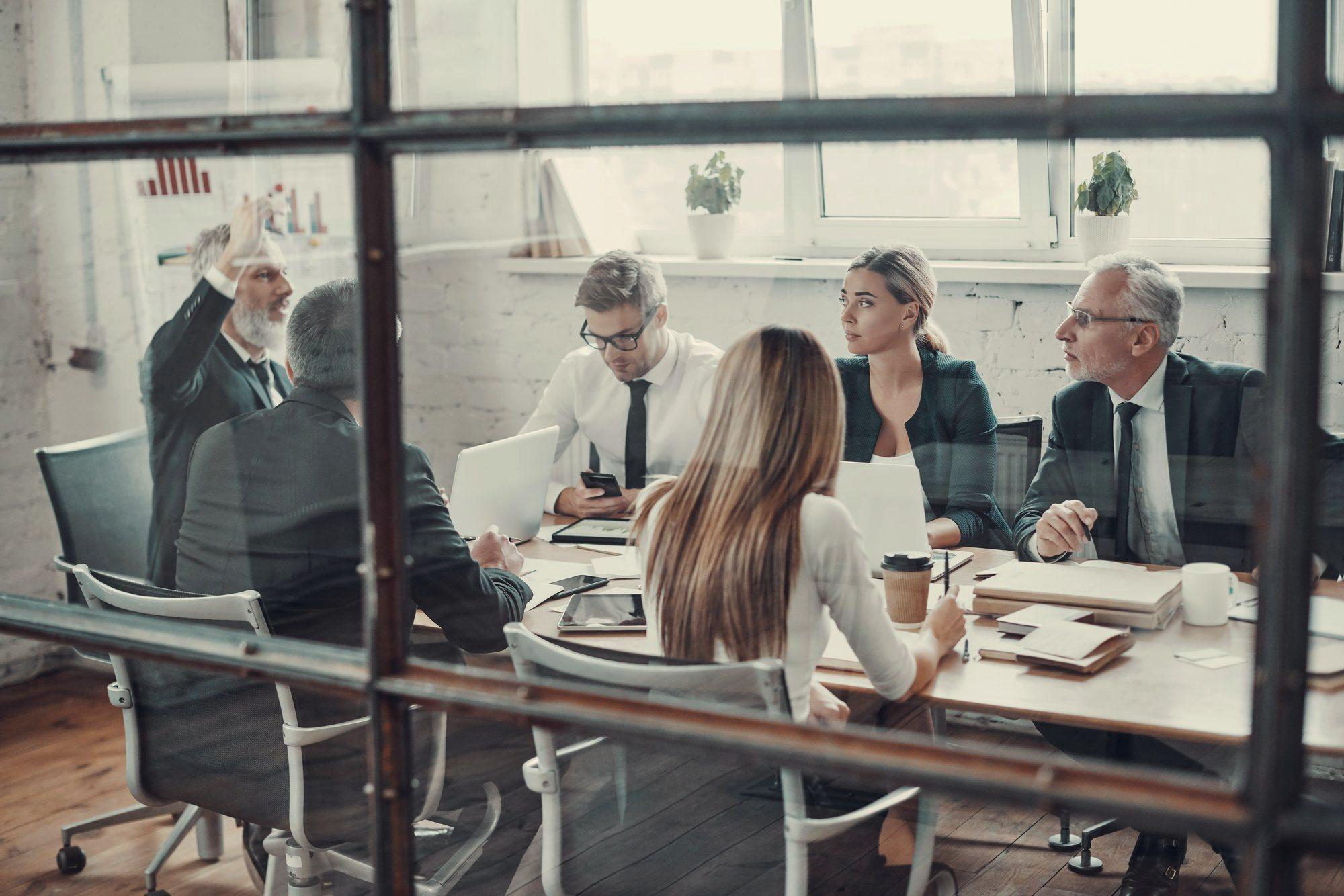 A leadership team in discussion around a boardroom table